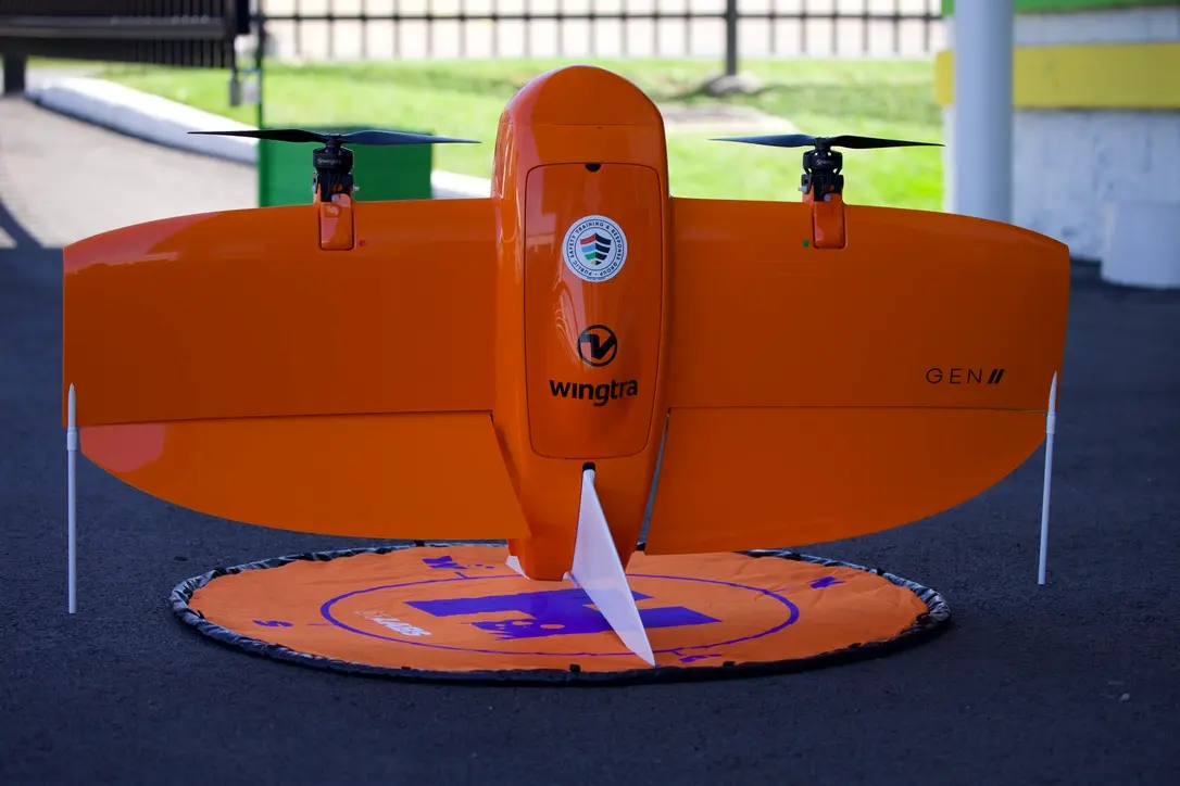 An orange rocket shaped like an airplane stands on a dark blue floor