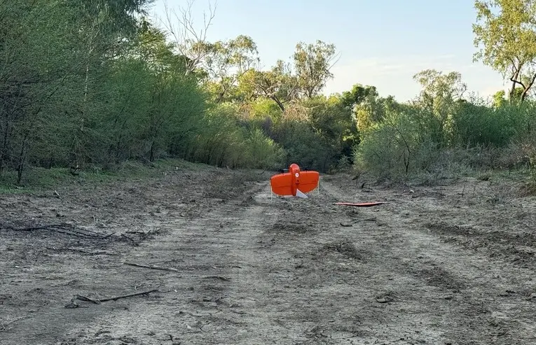 An orange rocket stands in the middle of the forest