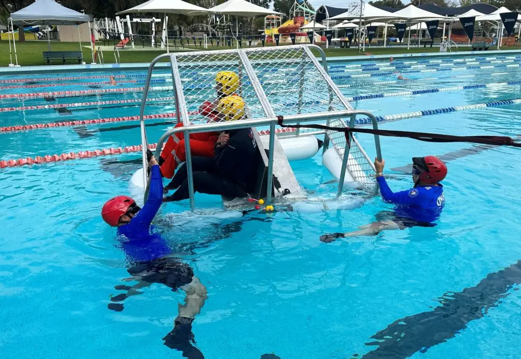 Swiftwater rescue cage training in pool with instructors demonstrating trapped-rescuer extraction – Public Safety Training & Response Group, Oxley, Brisbane, South East Queensland