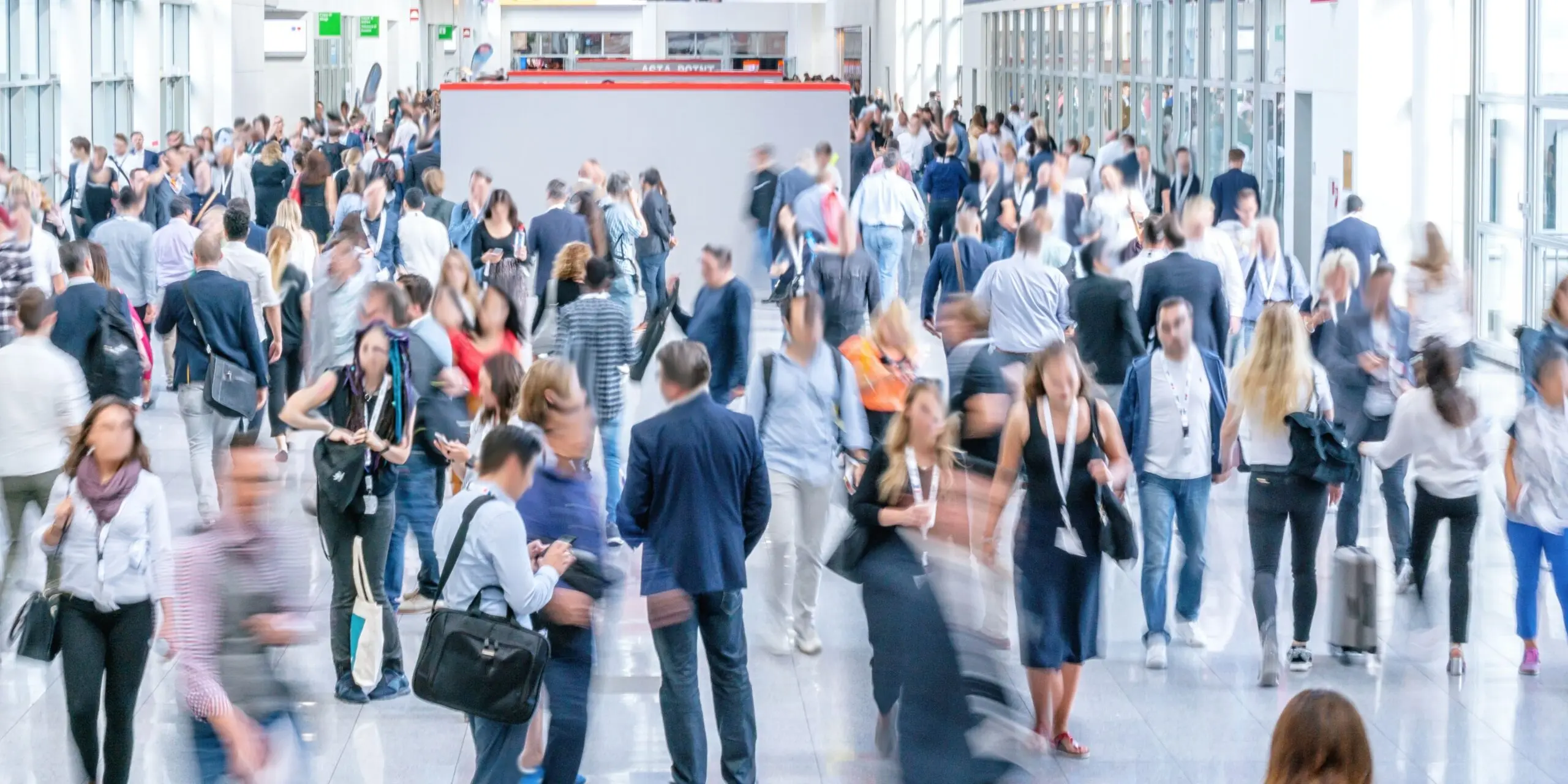 A crowd of people is moving frantically inside a white glass room