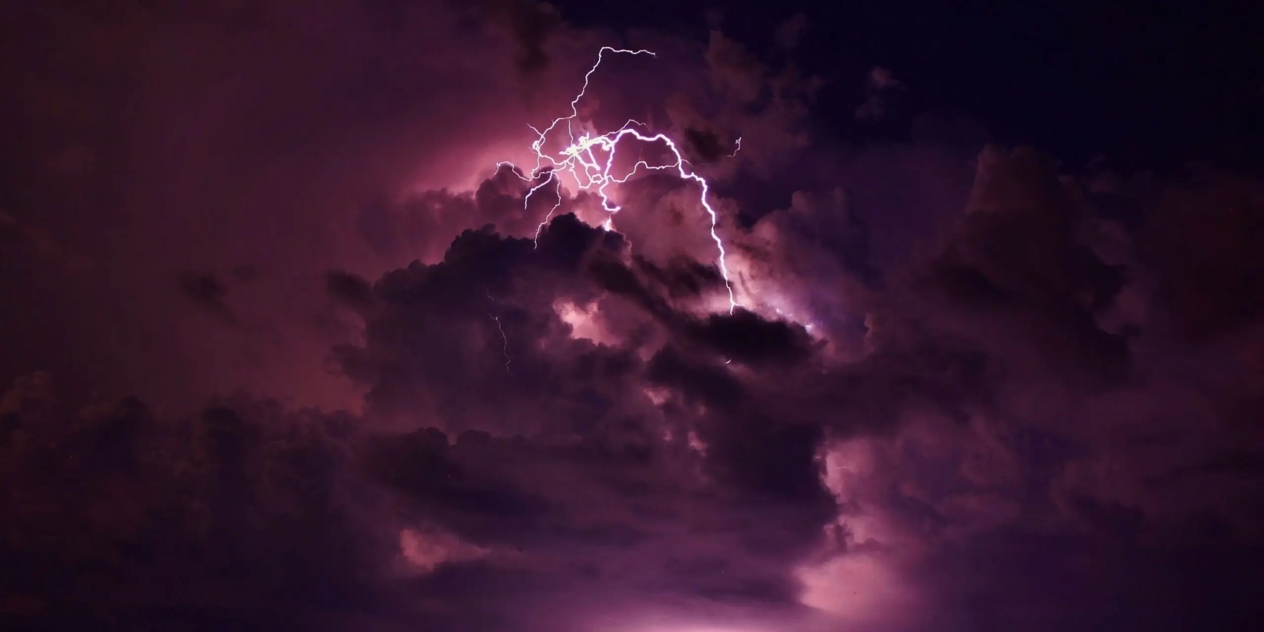A dark cloud features a purple lightning bolt striking through its center