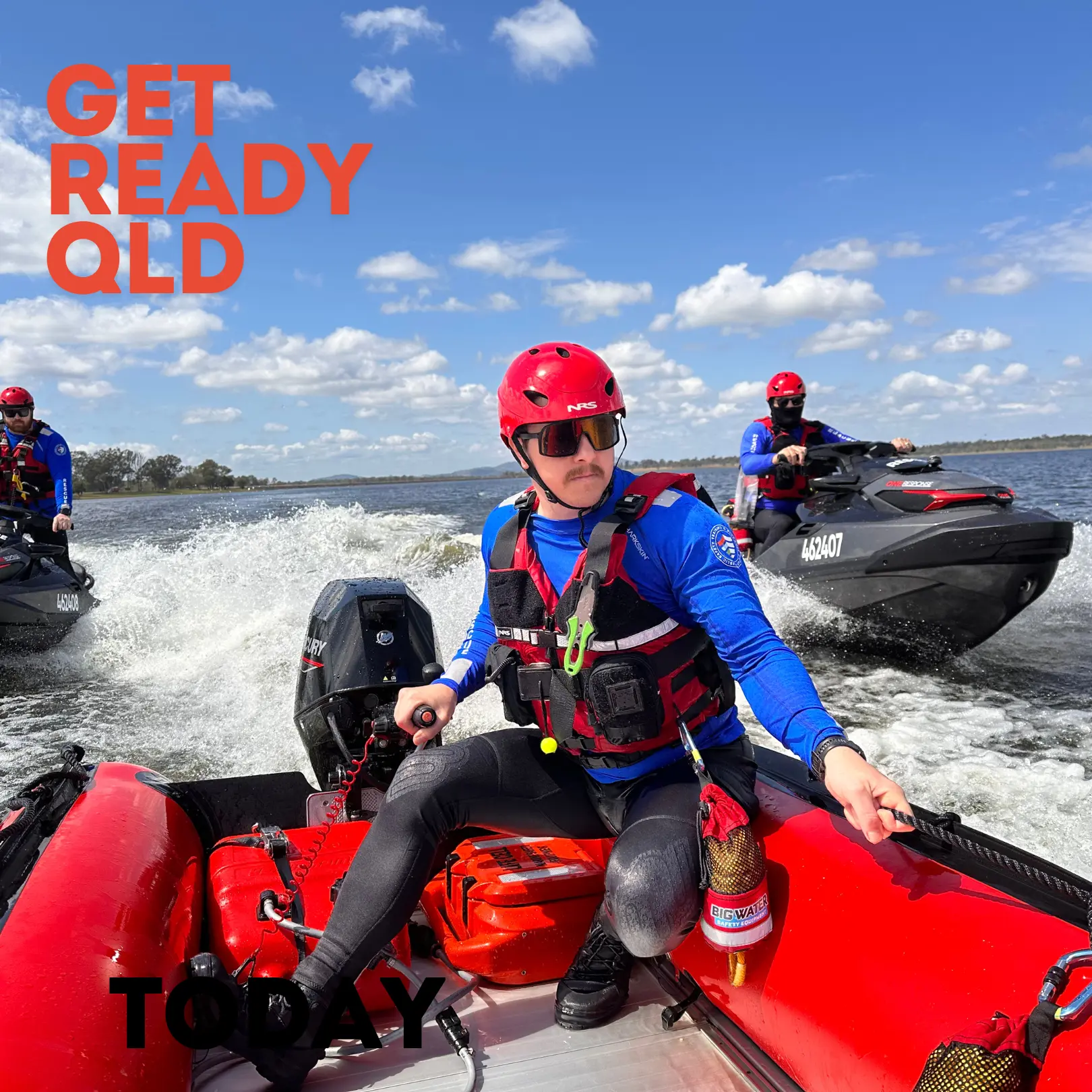 A man in a blue shirt, red vest, and red hat navigates a rubber boat through the river, flanked by black jet skis, with the words 'Get ready QLD' in red at the top right corner